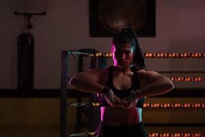 female Latina boxer with her hands bandaged working out at a training session at a gym throwing a punch photo