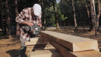 A skilled craftsman expertly operates a circular saw, cutting through timber planks in a serene forest setting. The sun filters through the trees as work unfolds. video
