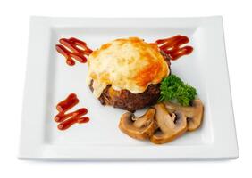 Meat with melting slice of cheese isolated on white background. photo