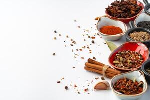 Bowls with various spices on white background photo