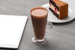 Chocolate cake with cup of cocoa on table photo