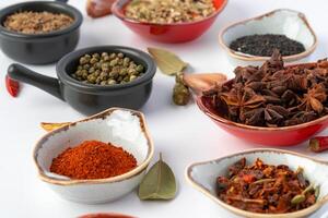 Bowls with various spices on white background photo