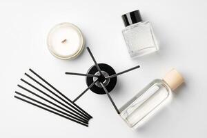 Aromatic essentials including scented candles, incense sticks, and diffusers arranged on a light background photo