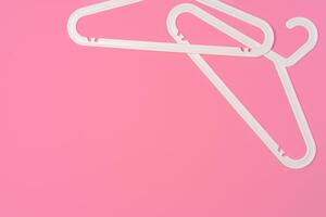 Flat lay composition with empty hangers on pink background photo