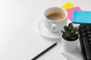 Office desk with laptop, blank notebook and coffee cup photo