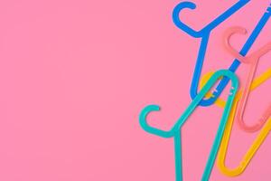 Flat lay composition with empty hangers on pink background photo