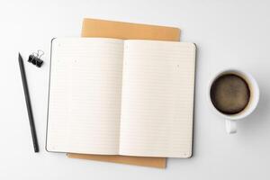 Cup of coffee and notepad on white background photo