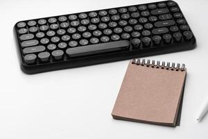 Minimalistic white workplace with keyboard and notebook photo