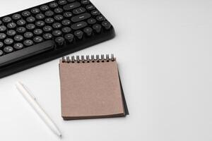 Minimalistic white workplace with keyboard and notebook photo