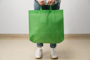 Cropped image of woman holding color shopping bag in studio photo
