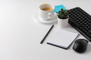 Office desk with laptop, blank notebook and coffee cup photo