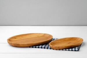 Wooden cutting board on cotton napkin on white wooden table photo