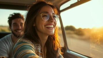 A joyful couple enjoys a sunset drive through scenic countryside with warm sunlight illuminating their faces photo
