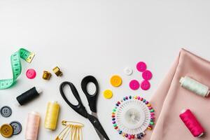 Crafting supplies arranged on a table with fabric, thread and buttons during daytime photo