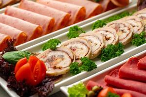 Platter of fresh meat cold cuts with vegetables. photo