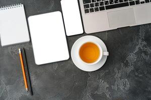 Digital tablet and coffee cup on gray table photo