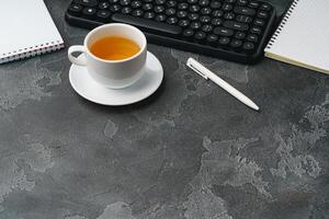 Office desk with computer keyboard, notepad and pen photo