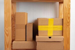 Stack of cardboard package boxes on wooden rack photo