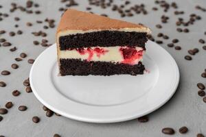 Multi-layer cocoa cake with berries on gray background photo