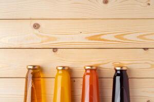 Juice bottles on wooden background flat lay photo