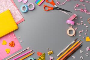 Crafting supplies arranged for a DIY project on a gray table with scissors, washi tape, and decorative items photo