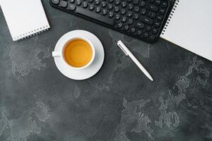 Office desk with computer keyboard, notepad and pen photo