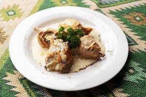 Chicken stewed in a creamy sauce on white plate photo