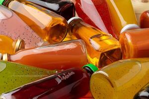 Different bottles of juice on wooden table photo