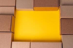 Beige cardboard boxes on yellow background, close up photo