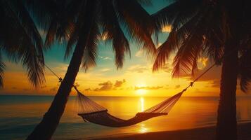 Relaxing hammock between palm trees at sunset near serene ocean waters on a tropical beach photo