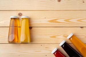 Juice bottles on wooden background flat lay photo
