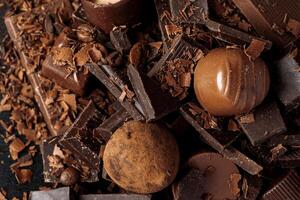 Grated chocolate and pieces of tasty chocolate on table photo