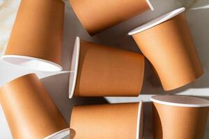 Brown disposable cups scattered on a white surface during daylight photo