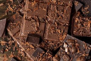 Grated chocolate and pieces of tasty chocolate on table photo