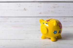 Piggy bank on wood table top photo