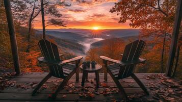 Two wooden chairs overlooking a stunning autumn sunrise in a tranquil mountain landscape with fog-filled valleys photo