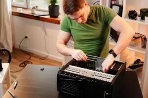 Man assembles a computer system unit at home photo