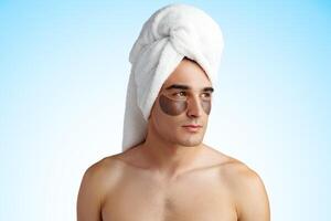Portrait of attractive young male model with eye patches on white background photo