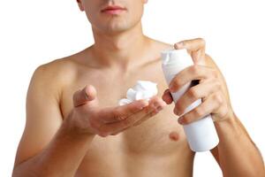Unrecognizable man holding shaving foam in hands against white background photo