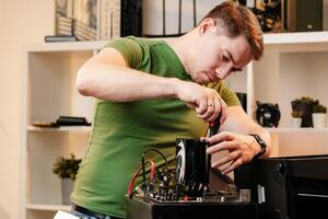 Man assembles a computer system unit at home photo