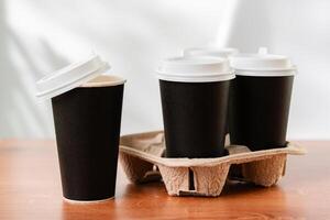 Stack of coffee cups in various colors with lids on a gray surface photo