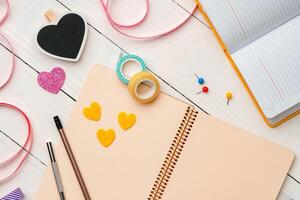 Creative workspace with colorful stationery and decorations on a white wooden desk photo