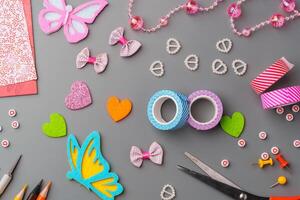 Crafting materials and tools arranged on a gray surface during a creative project photo