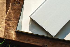 Books by the window on wooden background in sunlight photo