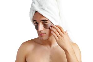 Portrait of attractive young male model with eye patches on white background photo