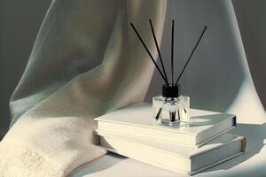 Liquid home perfume in glass diffuser with sticks on chair photo
