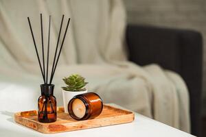 Aromatic reed freshener and candle on table in room photo