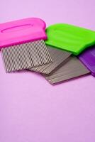 Three combs for removing lice and nits on lilac background photo