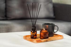Aromatic reed freshener and candle on table in room photo