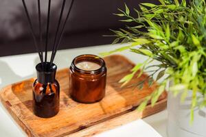 Aromatic reed freshener and candle on table in room photo